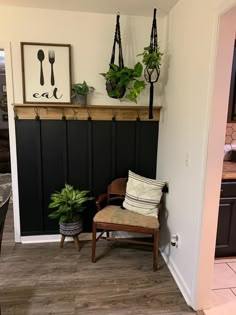 a room with a chair, potted plant and other items on the wall in it