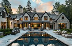 a large house with a pool in front of it and lots of chairs around the pool