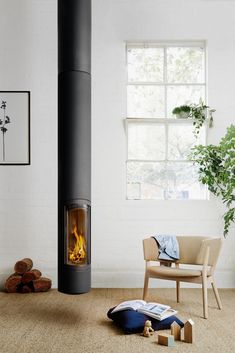 a living room with a fire place next to a chair and potted plant on the floor