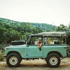 a woman sitting in the cab of a green jeep