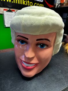 a white wig on top of a mannequin's head with blue eyes