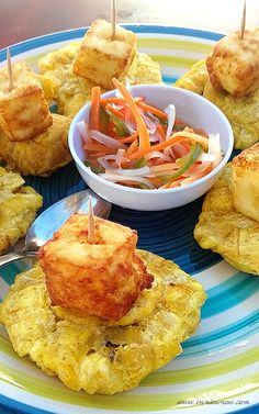 small appetizers with toothpicks are on a blue and yellow plate next to a bowl of cole slaw