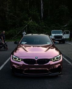 a pink bmw car parked in a parking lot