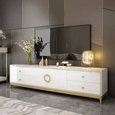 a living room with a large mirror on the wall next to a white dresser and some vases