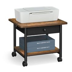 a printer sitting on top of a wooden table next to a white box and some books