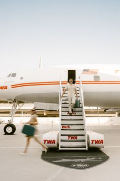 a woman walking up the stairs to an airplane