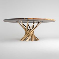 a round table with wooden sticks on the top and an oval metal plate at the base