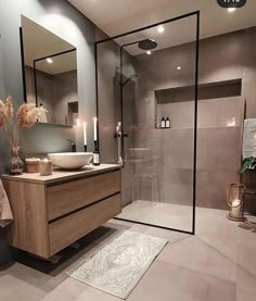 a bathroom with a sink, mirror and shower stall is shown in this image from the front view