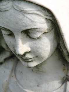 a close up of a statue with a hood on it's head and eyes closed