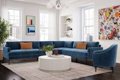 a living room filled with blue couches and chairs next to a white coffee table