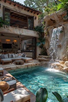 an outdoor living area with a waterfall and couches next to the pool in front of it