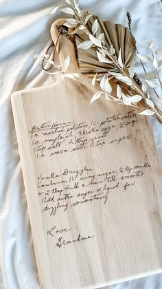 a piece of wood with writing on it next to some dried flowers and an umbrella