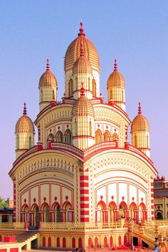 a large white and red building sitting on top of a lush green field