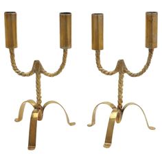 a pair of brass candlesticks with rope wrapped around the ends, on white background