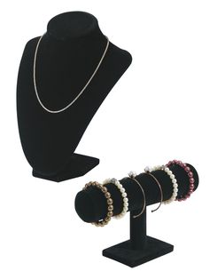 necklaces and bracelets are on display in front of a black mannequin