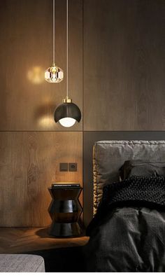 a bed sitting next to a wooden wall with two lights hanging from it's sides