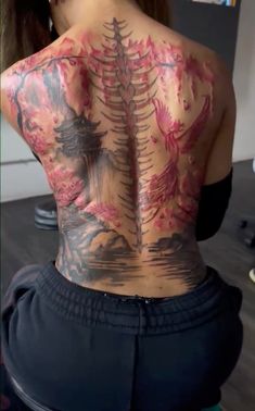 the back of a woman's body with tattoos on her upper and lower back