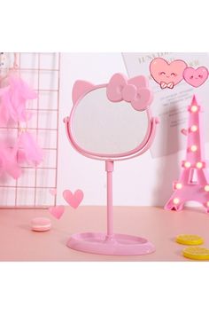 a pink hello kitty mirror on a table