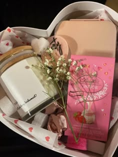 an open heart shaped box with flowers and personal items