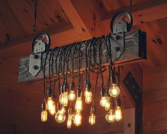 a bunch of light bulbs hanging from a wooden beam in a room with wood paneling