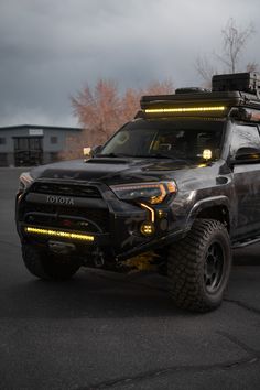 a gray truck with lights on it's roof and four wheels parked in a parking lot