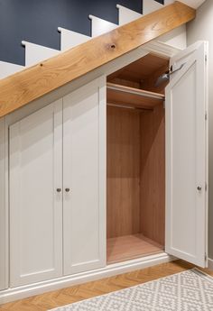 an open closet under the stairs in a house