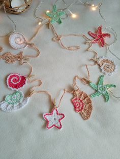 crocheted ornaments are arranged in a circle on a white tablecloth with string lights