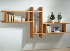 three shelves with books and vases on them