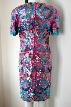 "So fun and so funky!! Vintage 80 sequin/bead hot pink, blue, silver dress! Sooo shiny and sparkly. You will definitely be the center of attention in this unique piece! 100% silk Zips in the back and is in Very good condition! I do not see any sequin loss. Hot pink silk lining Stunning geometric design with beautiful details Measuring: 38\" long Bust: 34\" Waist: 30\" Hip 36\" Pet free/ smoke free Enjoy!" Pink Sequin Fabric For Night Out And Holiday, Pink Sequin Fabric For Holiday And Night Out, Disco Style Embellished Sequin Dress For Party Season, Disco Embellished Sequin Dress For Party Season, Party Season Disco Embellished Sequin Dress, Disco-style Embellished Sequin Dress For Party Season, Pink Glitter Dress For Party Season, Pink Glitter Dresses For Party Season, Fitted Disco Dress With Contrast Sequin