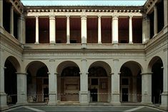 the inside of an old building with columns and arches on it's sides,