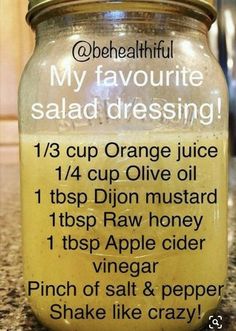 a jar filled with orange juice sitting on top of a counter