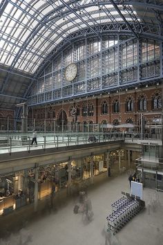 the inside of a train station with people walking around