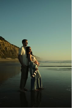 a man and woman embracing on the beach