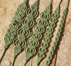 three green crocheted laces sitting on top of a stone slab next to each other