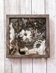 a wooden frame with flowers and other items in it on a white wood background that says grace of hope