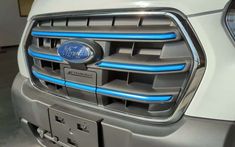 the front grille of a white ford truck with blue lights on it's grill