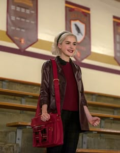 a woman holding a red purse and smiling