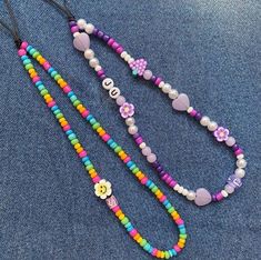 two necklaces with beads and hearts on them sitting next to each other in the shape of flowers