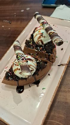 two pieces of chocolate cake with ice cream and sprinkles on a white plate