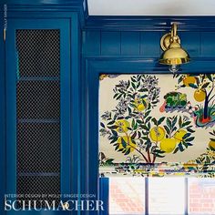 a kitchen with blue cabinets and yellow flowers on the wall