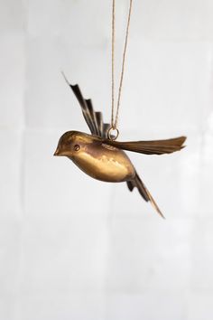 a gold bird ornament hanging from a chain