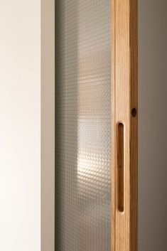 a glass door in the corner of a room with white walls and wood trimming