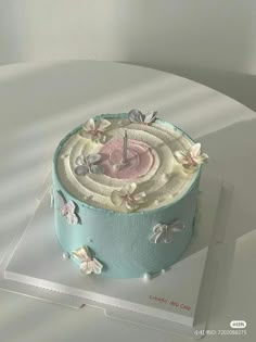 there is a blue cake with flowers on it