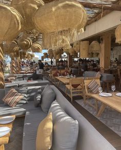 an outdoor restaurant with tables, chairs and umbrellas hanging from the rafters above