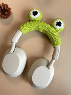 a pair of headphones sitting on top of a table next to a pine cone