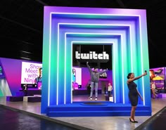 a woman standing on stage in front of a tv screen with the words tech next to it