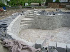 an unfinished pool is being built in the middle of a residential area with concrete walls and steps