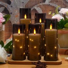 five lit candles sitting on top of a wooden table