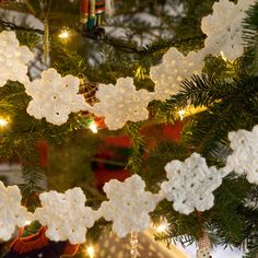 white crocheted snowflakes hanging from a christmas tree