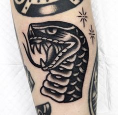 a black and white tattoo with a snake on it's arm that has a crown above it